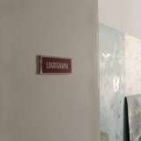 Proseguiamo il nostro giro. Sulle porte di alcune stanze si trova ancora la targhetta che ne indicava il reparto, come quella di colore rosso castagno che recita �logoterapia�